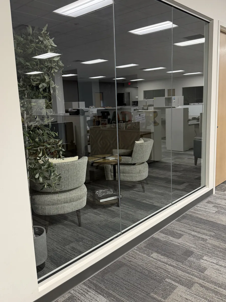 Sala de oficina con paredes de vidrio impecable, limpiada por Maloon
